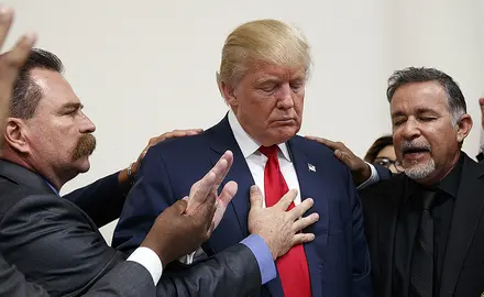 Men pray with Donald Trump