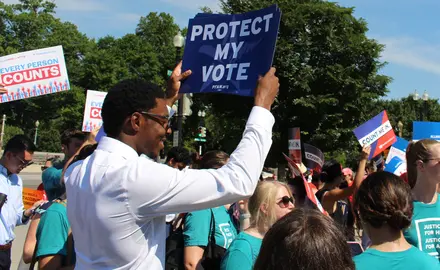 Activists hold signs that say "Every person counts" and "Protect my Vote"