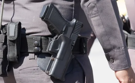 Close up of the gun on a police officer's belt