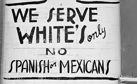 An old sign with the text "We serve white's only. No Spanish or Mexicans."