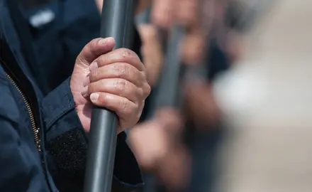 Close up of a police officer holding a baton