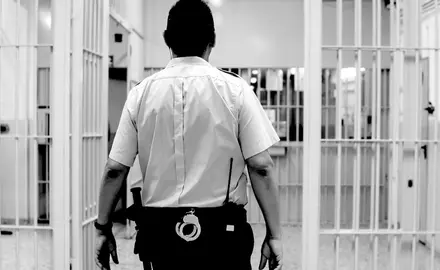 A prison guard walks through the hallways of a prison.