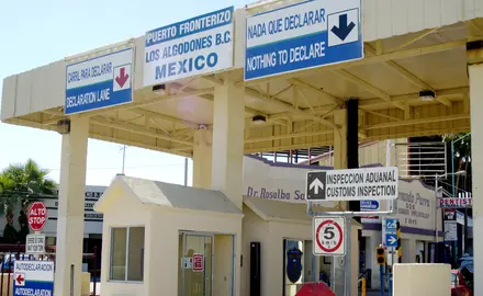 A border control checkpoint with signs in both English and Spanish