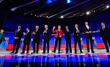 Democratic presidential candidates stand on a stage during a debate in 2019.