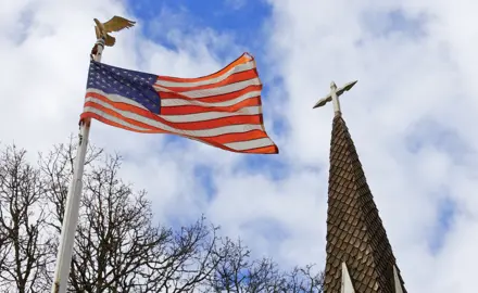 An American flag and a church steeple