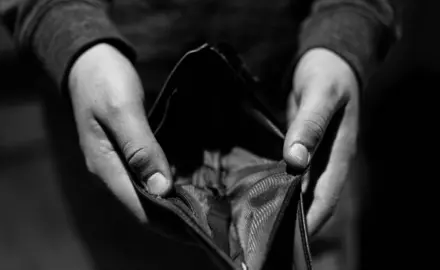 A person holds open an empty wallet