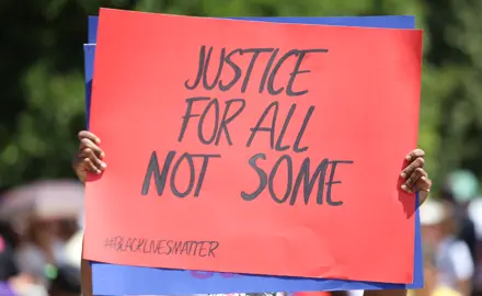 At a Black Lives Matter protest, a sign reads "Justice for All, Not Some."