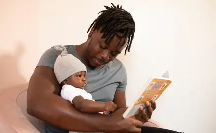 Black father reading to child