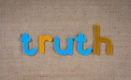 The word "truth" in colorful tiles on a beige background.