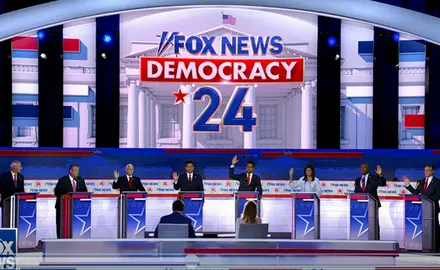 GOP presidential candidates raising their hands behind podiums at the GOP debate.