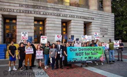 A group of people protest outside ALEC's 50th anniversary event.