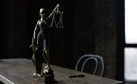 A statue of lady justice sitting on a table.