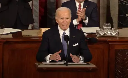 President Joe Biden stands at podium delivering the 2024 State of the Union address.