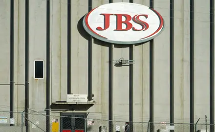 A sign on a wall that says "JBS"