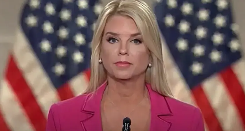 Image of Pam Bondi speaking at RNC, standing at microphone in bright pink suit with American flags visible behind her. 