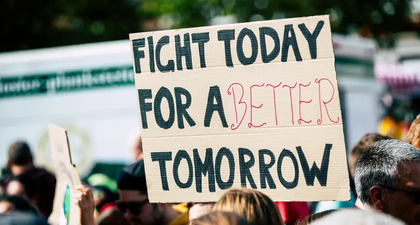 Protesters holding a sign that reads "fight today for a better tomorrow"