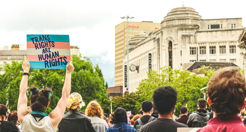 protestors holding a sign that reads "trans rights are human rights"