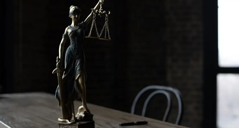 A statue of lady justice sitting on a table.