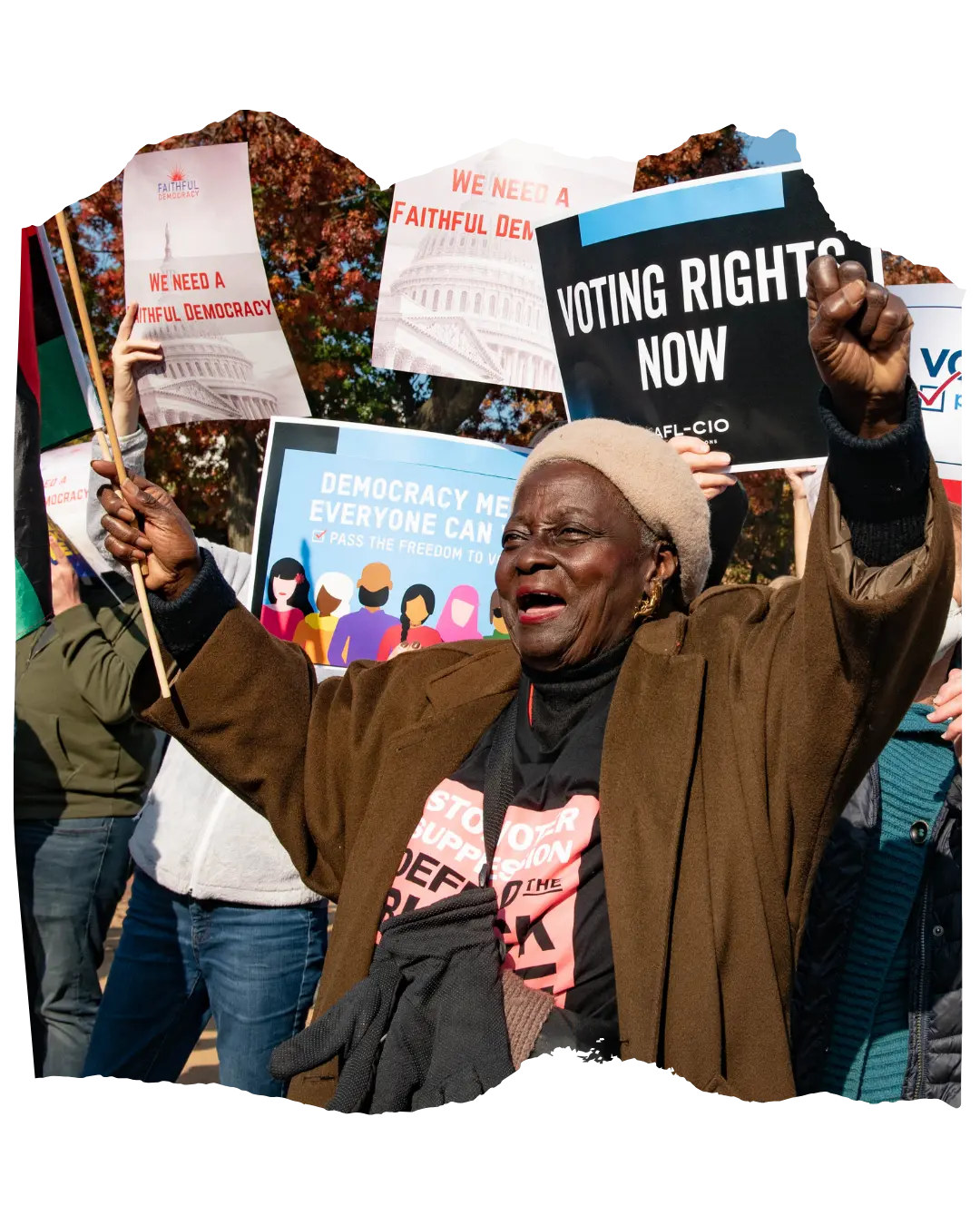 Older woman at a protest in front of a sign that says "voting rights now"