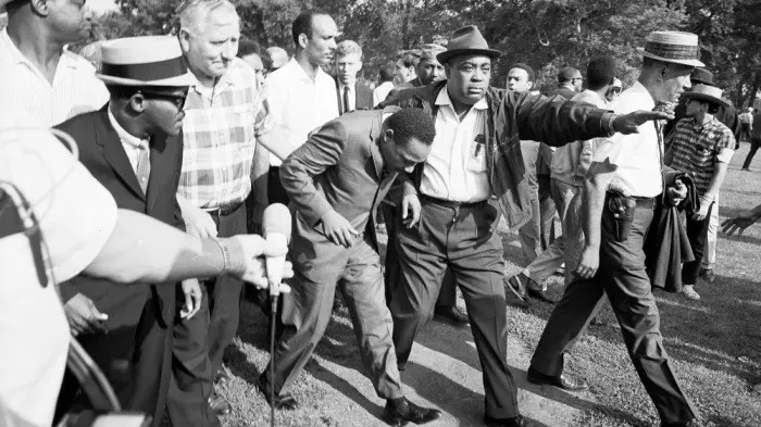 Civil rights protesters, including Martin Luther King, Jr., march toward a realtor's office in 1966