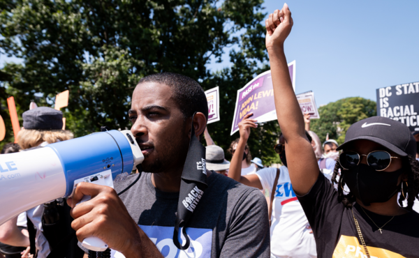 A black man holding a megaphone at a protest