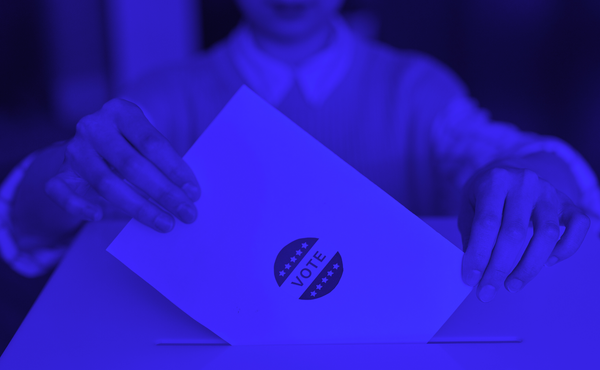 Blue photo of someone submitting a ballot