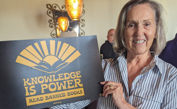Woman holding a sign that says Knowledge is power, read banned books