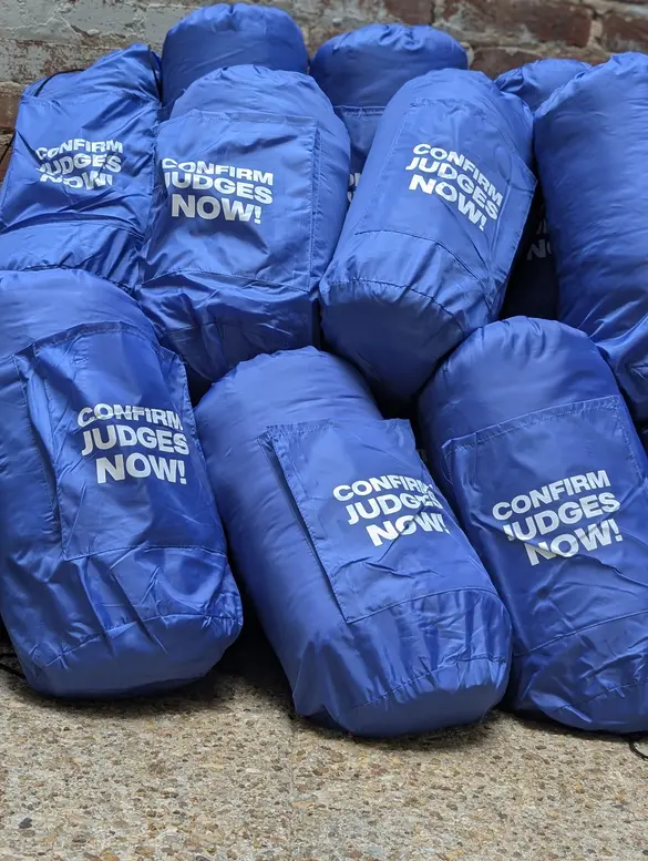 A pile of sleeping bags that say "confirm judges now"