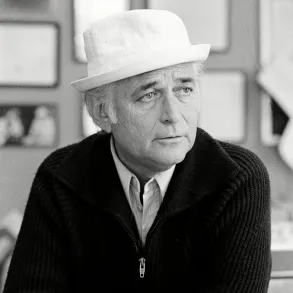 Black and white picture of Norman Lear wearing his iconic hat looking to the right