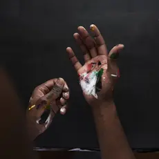 Artist's hands covered in paint