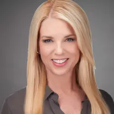 Pam Bondi headshot; white women with long blonde hair below shoulders smiles into the camera. 