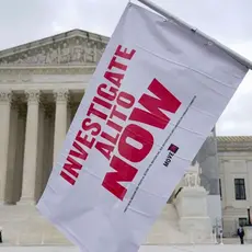 A flag for the investigation of Justice Alito is waved at an event outside the Supreme Court in Washington, D.C.