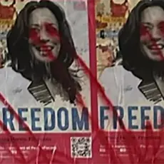 Posters of Kamala Harris with the word "Freedom" covered it red spray paint