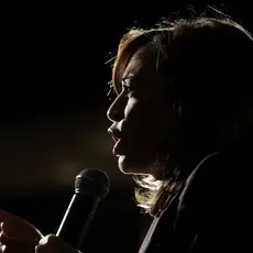 Vice President Kamala Harris speaks into a microphone