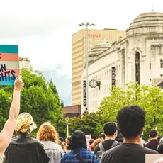 protestors holding a sign that reads "trans rights are human rights"