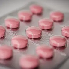 a packet of round, pink pills.