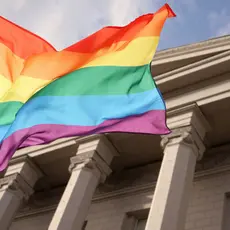 A rainbow flag in front of a building.