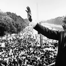 A photo of Dr. Martin Luther King Jr. waving to a crowd at the national mall.