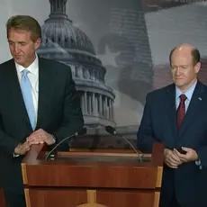 Jeff Flake and Chris Coons stand at a podium