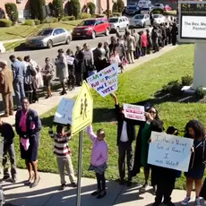 A group of people outside a church holding signs