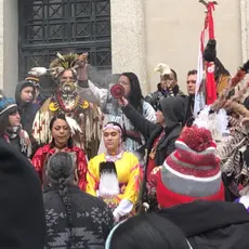 A group of indigenous people surrounded by onlookers