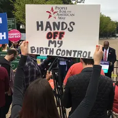 People hold signs that say "Enough is enough," "Hands off my birth control" and "Don't take away our health care ever"