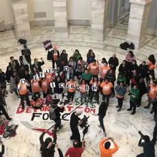 A group of protesters hold signs that say "Defund ICE and CBP"