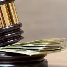 A gavel resting on a stack of money