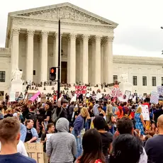 A group of people rallies outside of the Supreme Court