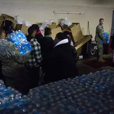 Members of the Michigan National Guard distribute bottled water to residents.