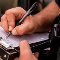 A close up of a police officer writing a ticket