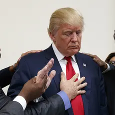 Men pray with Donald Trump