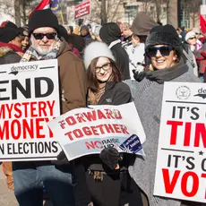 Protesters hold signs and participate in the 10th Annual Moral March