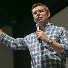 Democratic presidential candidate Eric Swalwell wearing a blue plaid shirt and answering a question